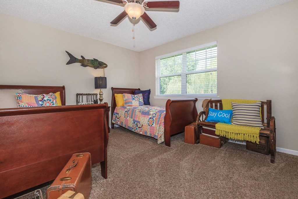 a bedroom with two beds and a ceiling fan