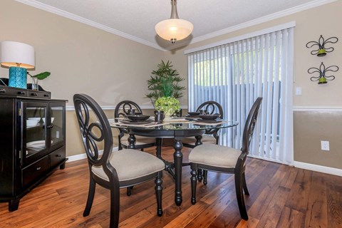 a dining room with a table and chairs and a window