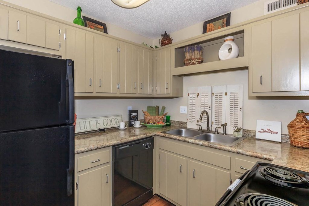 a kitchen with white cabinets and black appliances