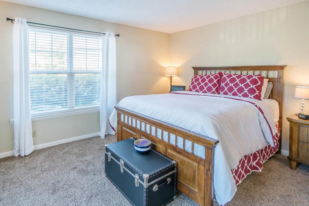 a bedroom with a bed and a trunk on the floor