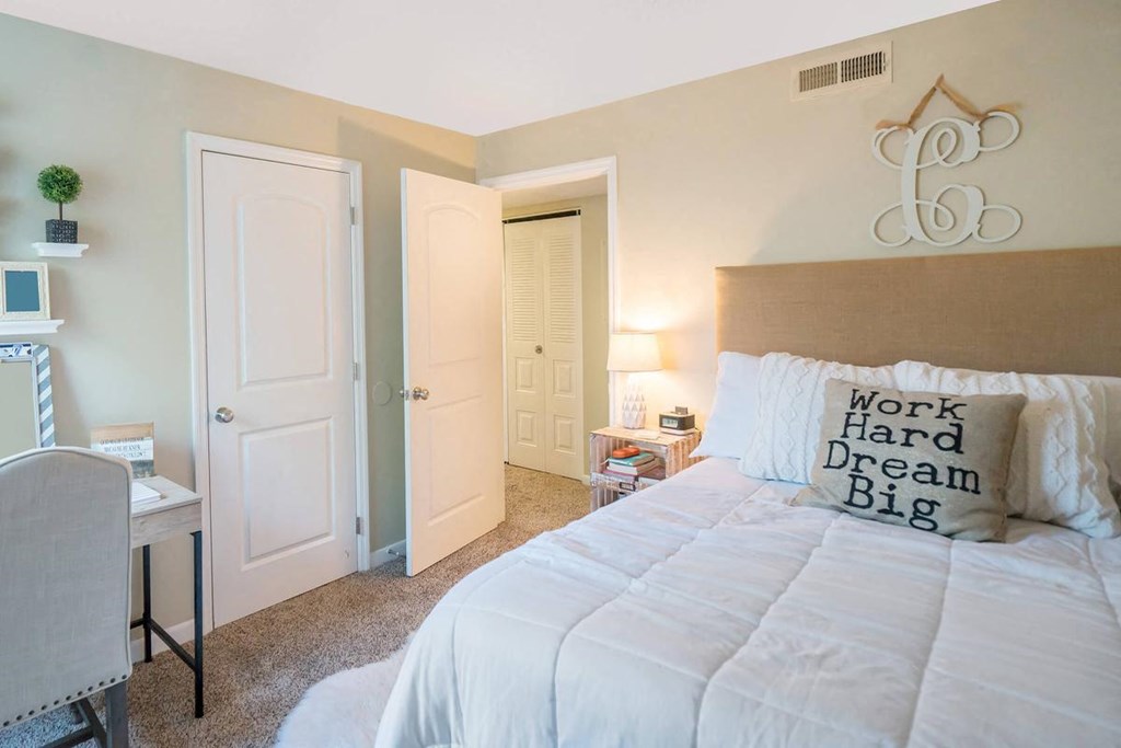 a bedroom with a bed and a desk and a closet