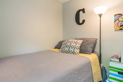 a small bedroom with a bed and a lamp