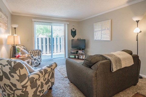 a living room with a couch and chairs and a tv