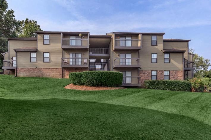 an apartment building with green grass in front of it