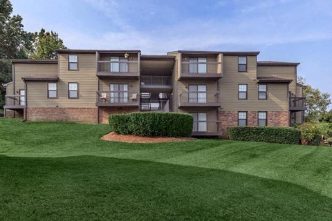 an apartment building with green grass in front of it