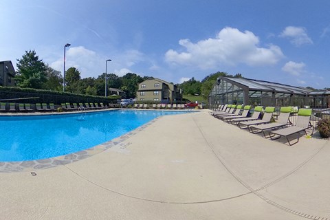 a large swimming pool with chaise lounge chairs on the side of it