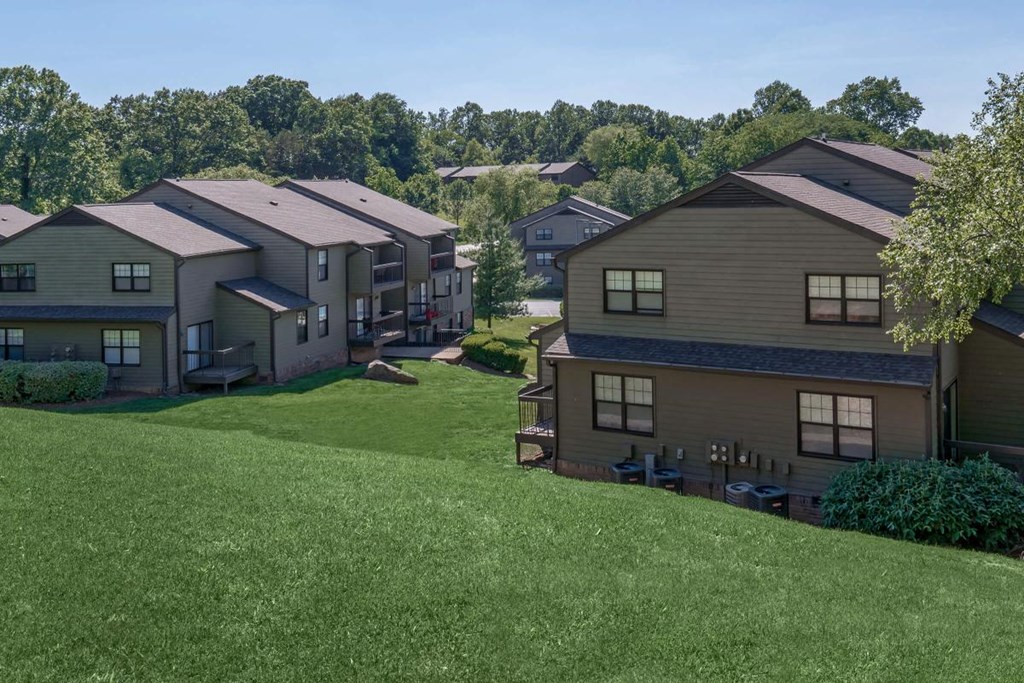 an aerial view of houses on a grassy hill
