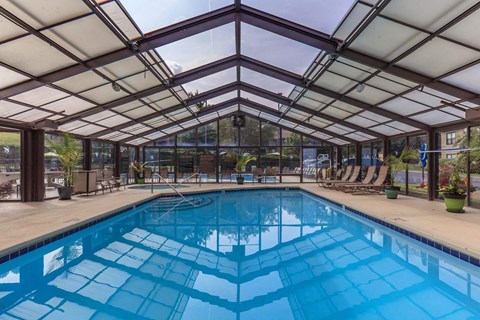 the indoor pool is heated and has glass walls and a ceiling