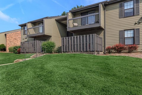 a yard in front of a house with a fence