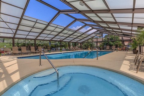 a pool with a hot tub under a glass roof
