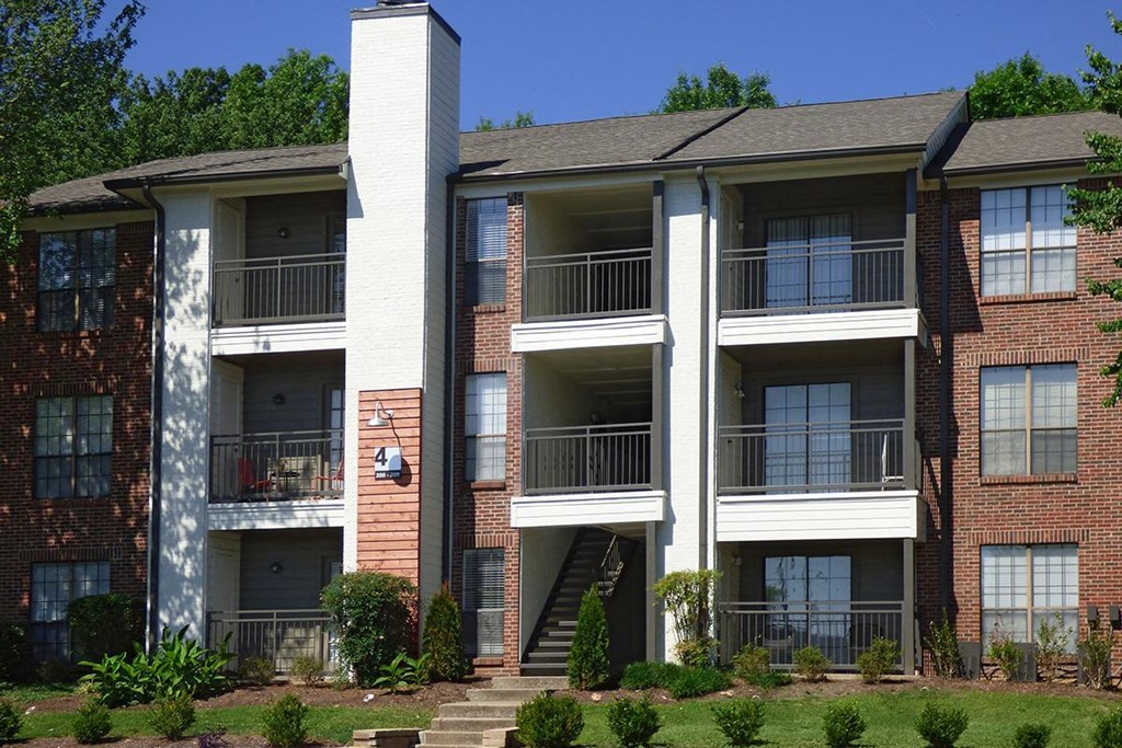 an apartment building with brick and white balconies
