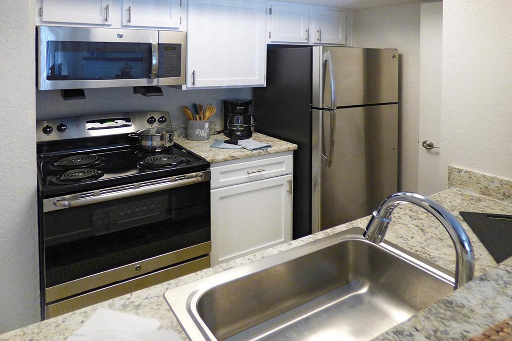 a kitchen with a sink and a stove and a refrigerator