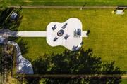 an aerial view of a guitar shaped field in the grass