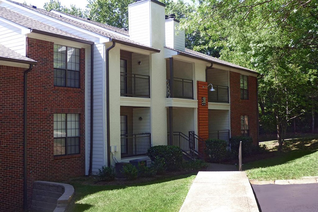an apartment building with a sidewalk in front of it