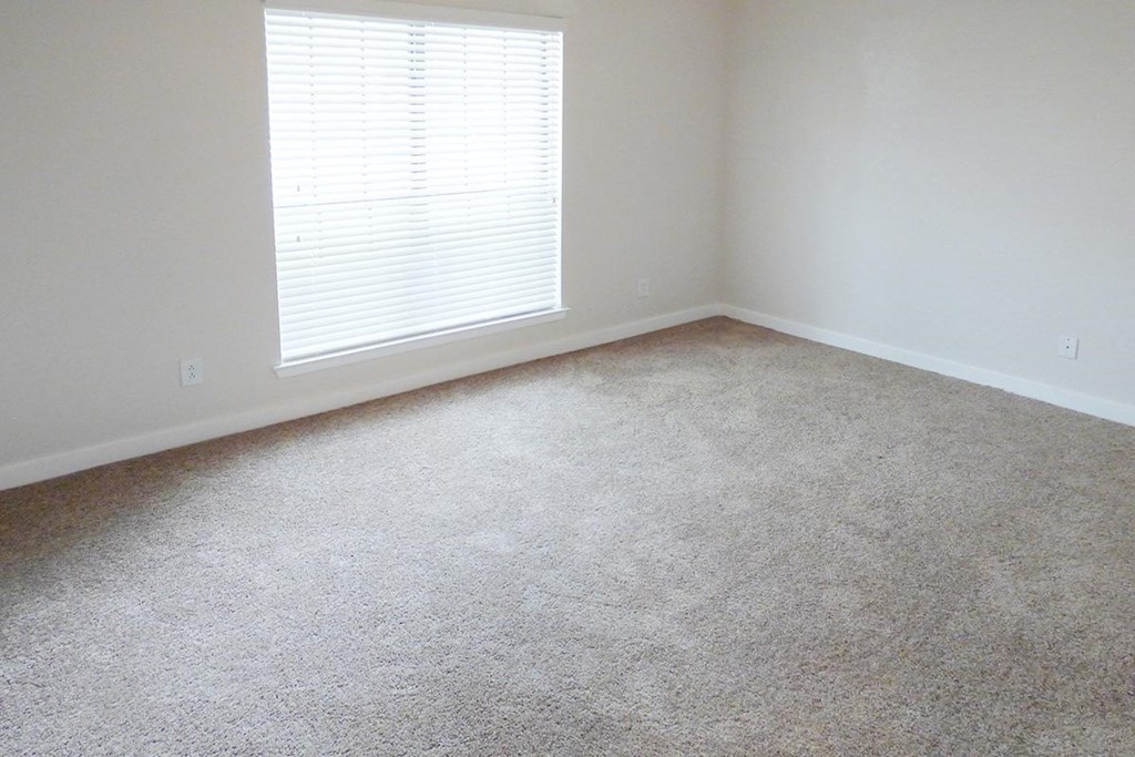 a room with a carpeted floor and a window