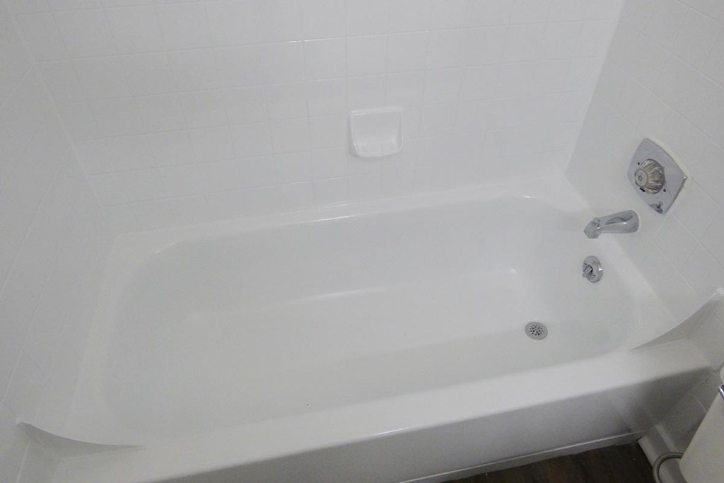 a white bath tub in a bathroom with a sink