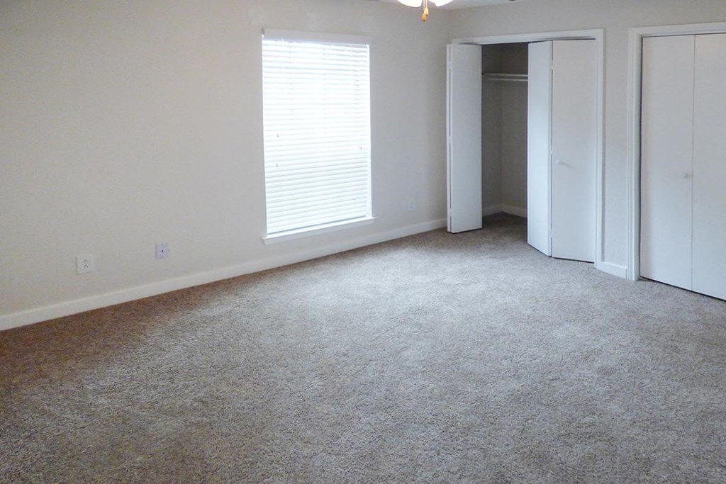 an empty room with a carpeted floor and white walls