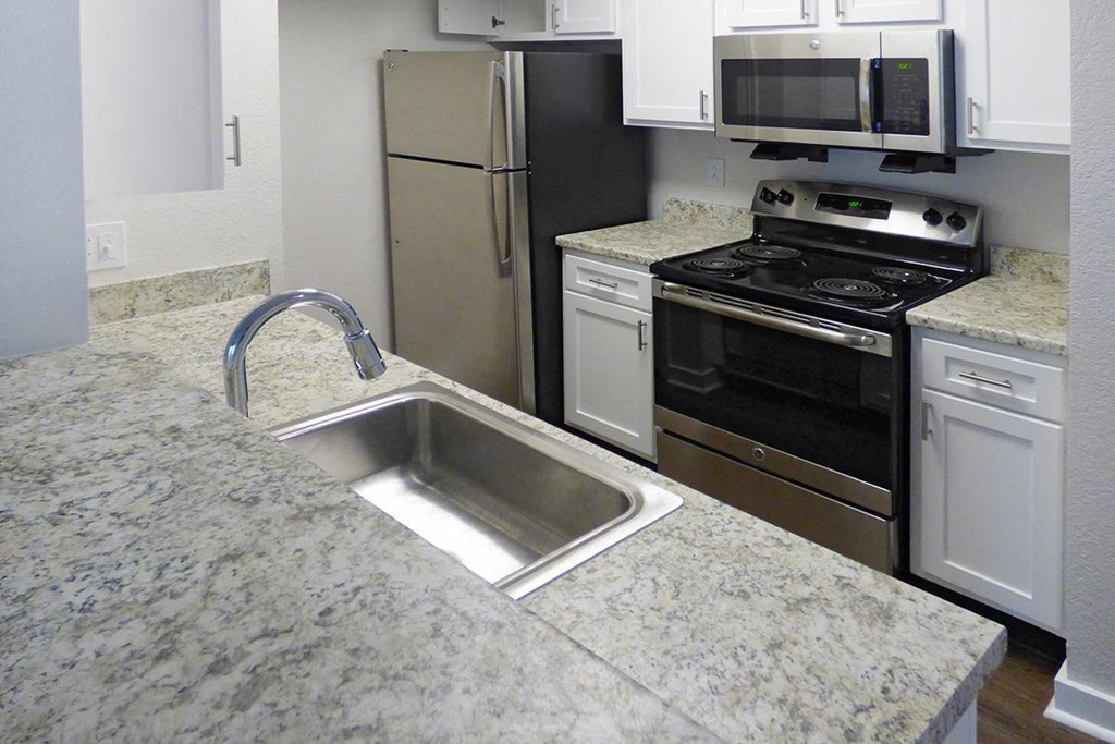 a kitchen with granite counter tops and stainless steel appliances