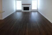 an empty living room with wood floors and a fireplace
