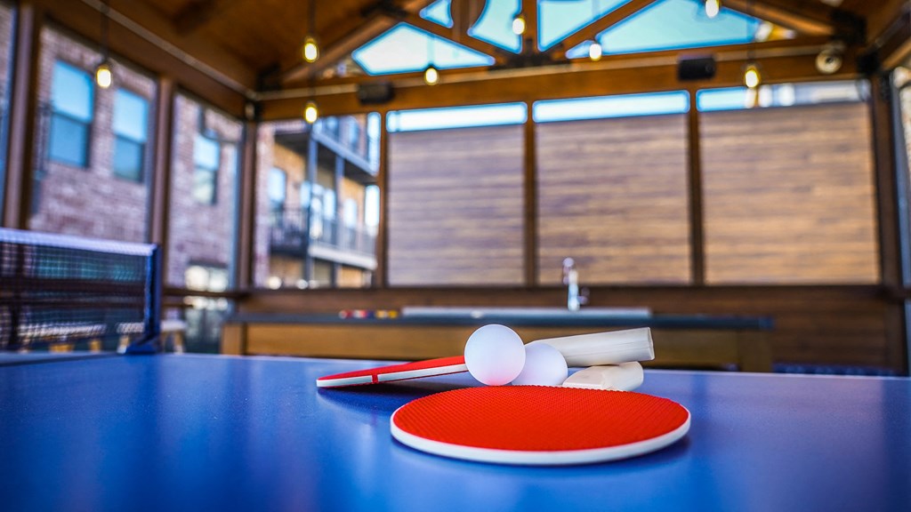 a ping pong paddle and two balls on a table