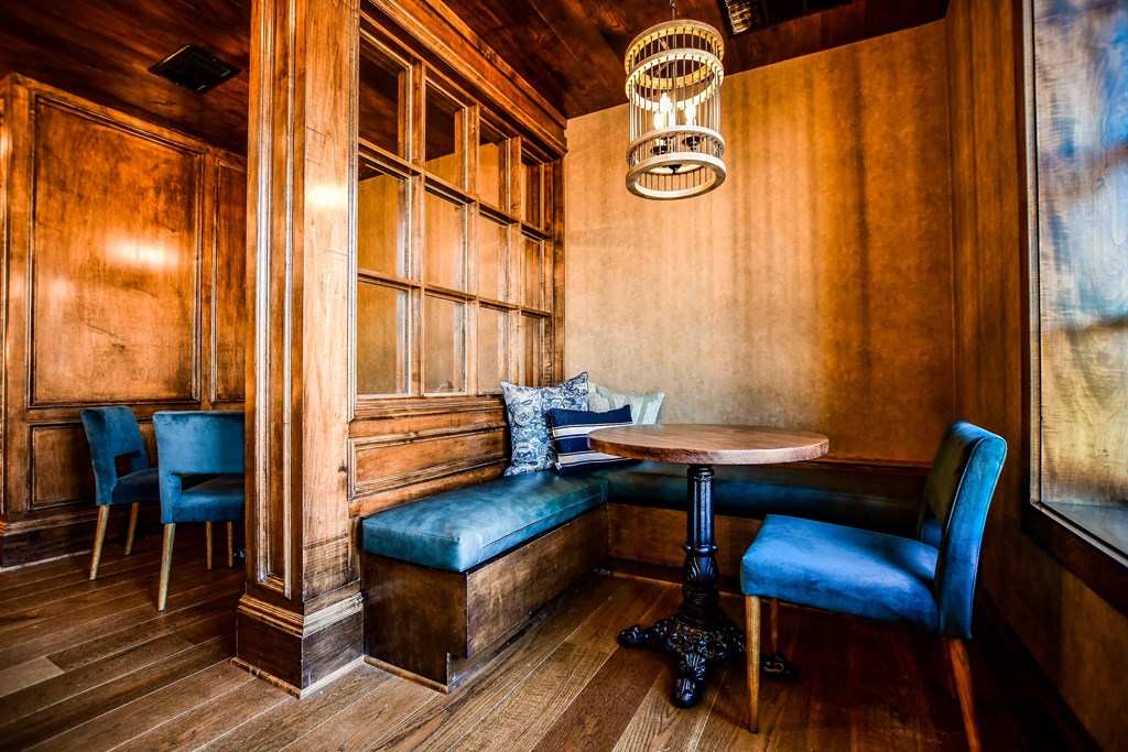 a small booth with blue chairs and a table