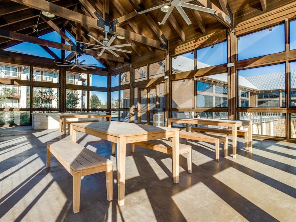 a dining area with wooden tables and benches in a building with large windows