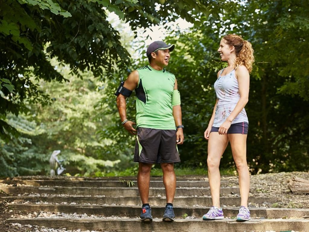 a man and a woman standing on steps in a park