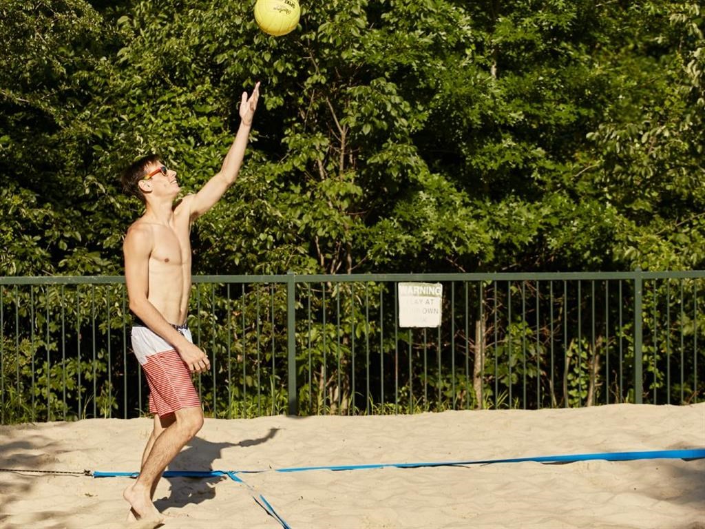 a man jumping up to catch a volleyball