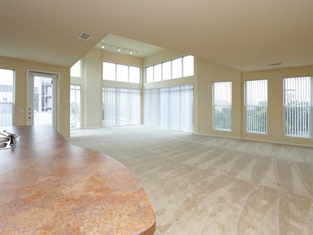 an empty living room with large windows and a wooden table