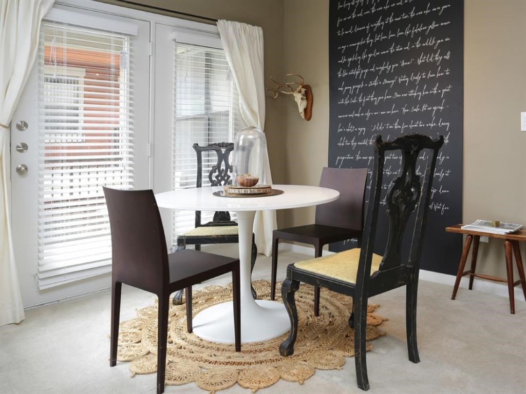 a dining room with a table and chairs and a chalkboard wall