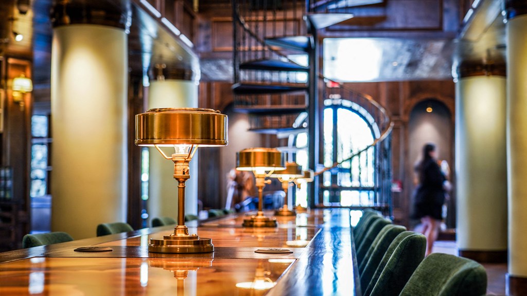 a long wooden bar with gold lamps on it
