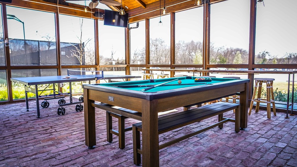 a pool table in a game room with windows