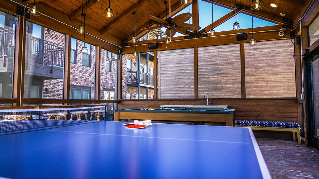 a ping pong table in a large room with windows