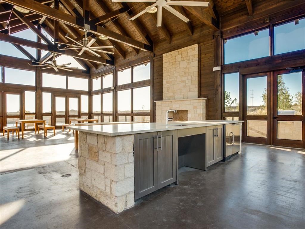 a large kitchen with a large island and a stone fireplace