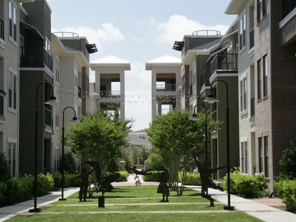 a rendering of an apartment complex with trees and grass