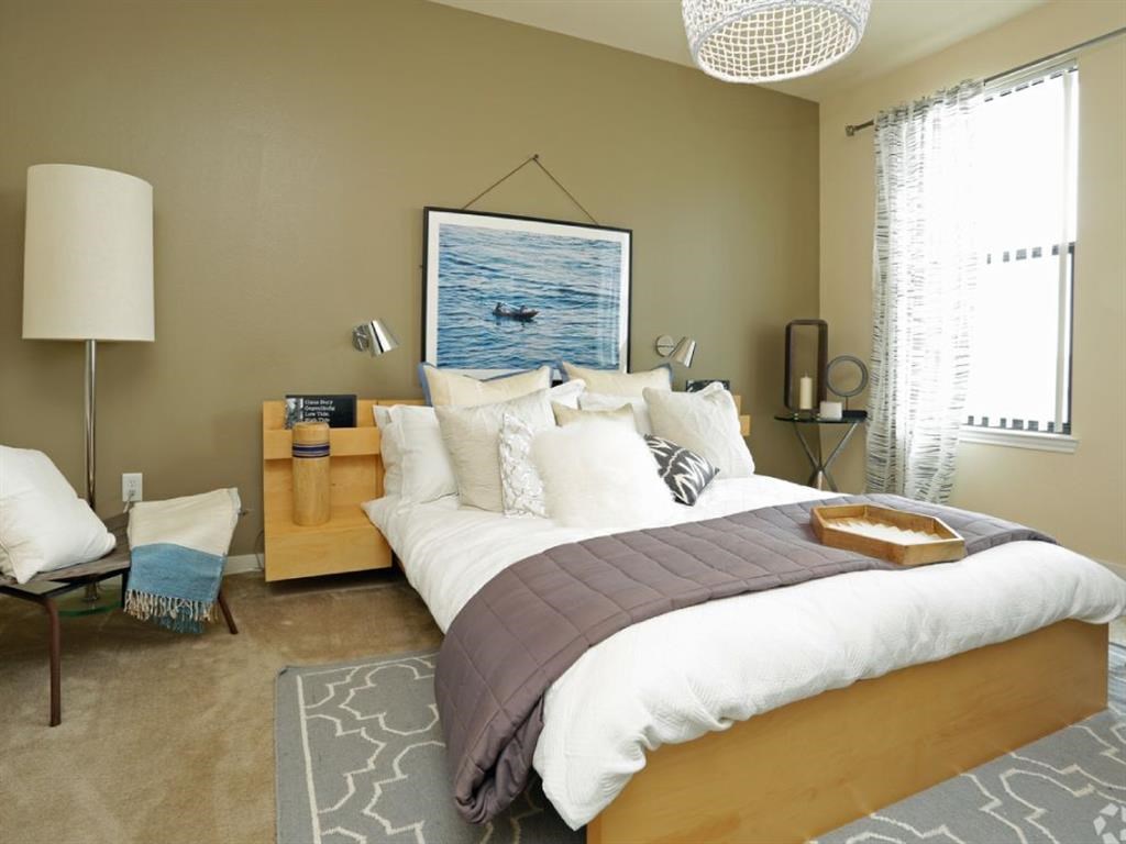 a bedroom with a bed and a picture of the ocean on the wall