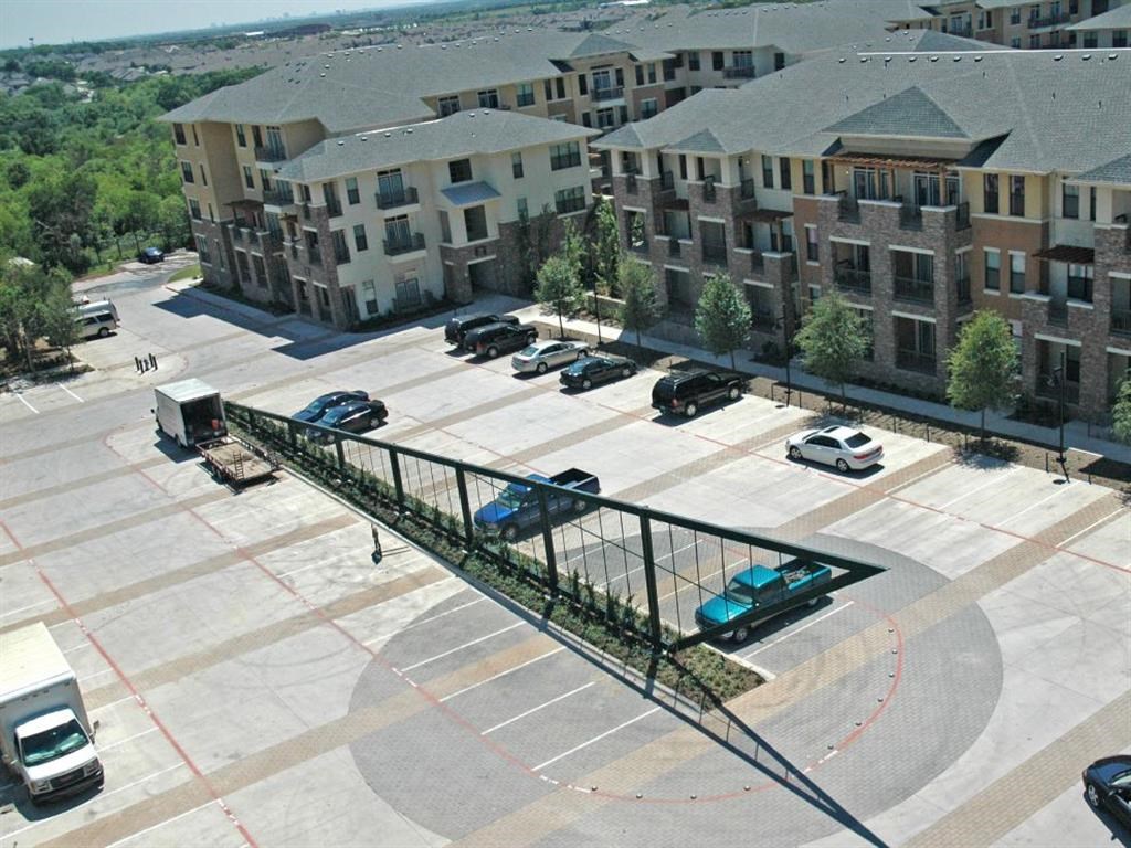 an aerial view of an apartment complex with cars parked in a parking lot
