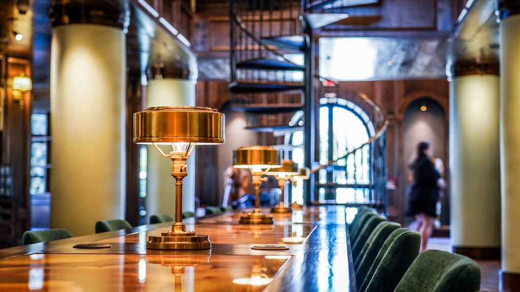 a long wooden bar with gold lamps on it