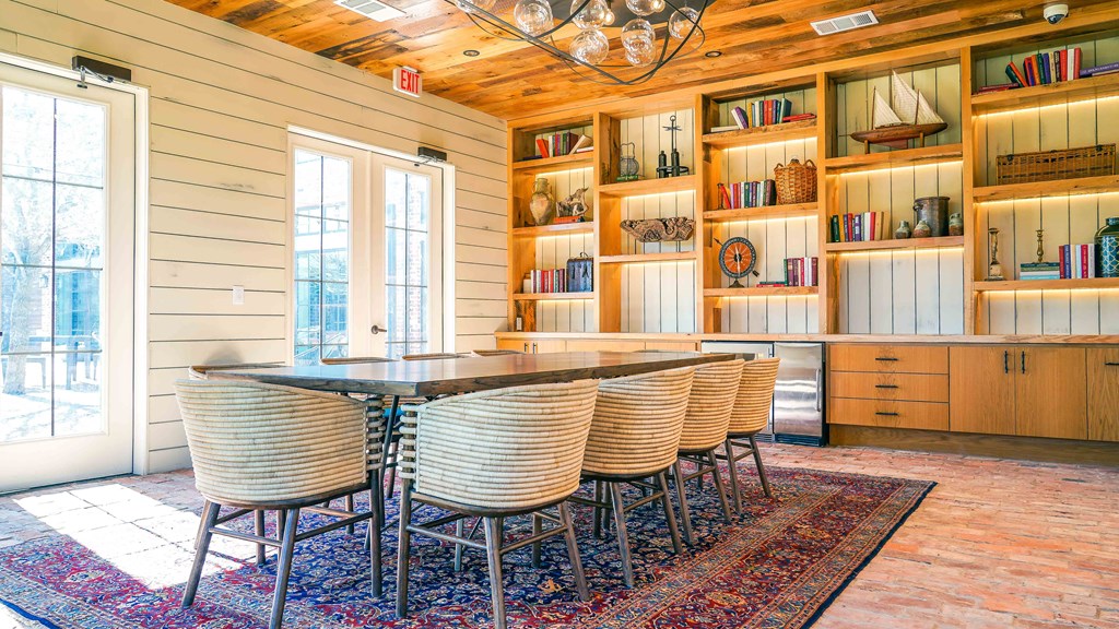 a dining room with a table and chairs in front of a wall of bookcases