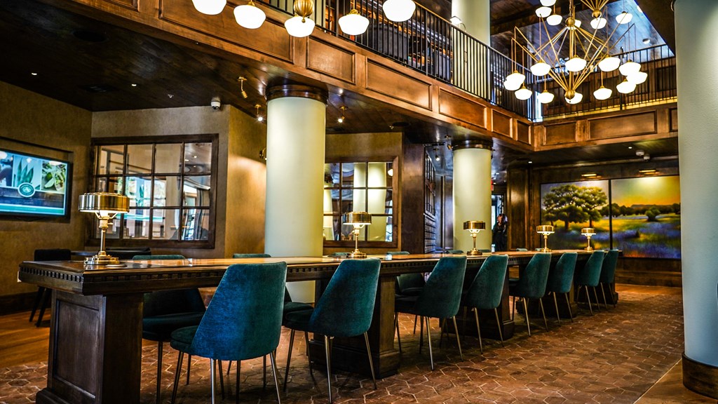 a bar in the lobby of a hotel with blue chairs