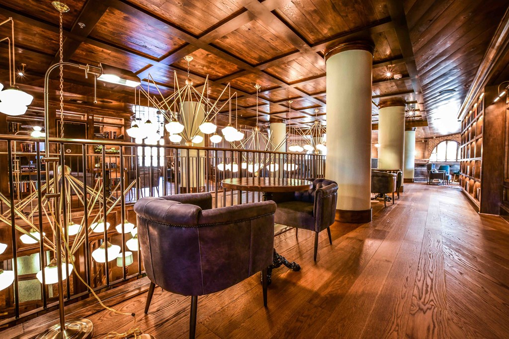 a bar with leather chairs and a wooden ceiling