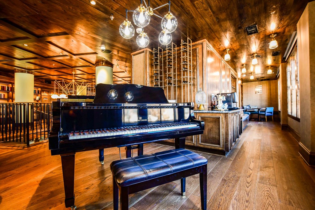 a piano in the center of a room with a bar in the background