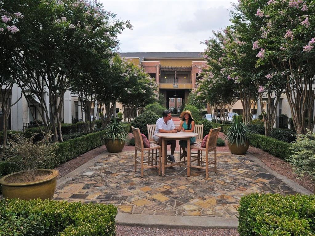 a couple sitting at a table in a courtyard