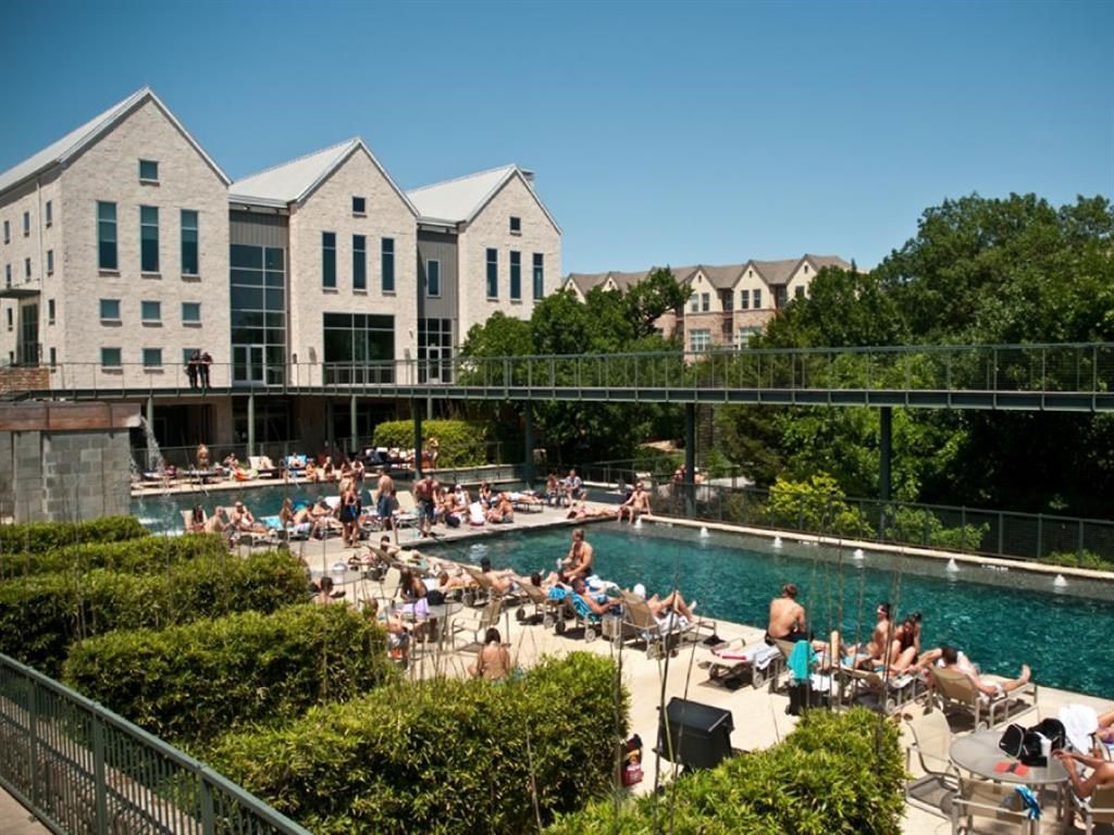 people swimming in a pool at the resort on a sunny day
