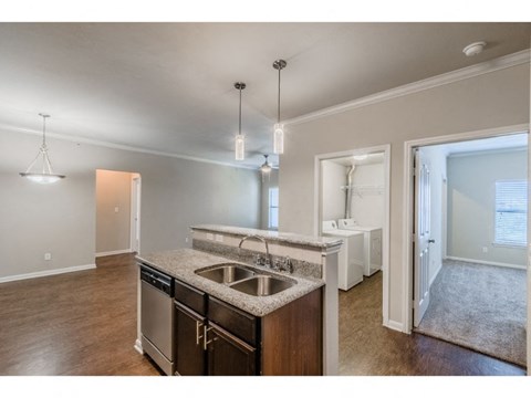 a kitchen with a sink and a door to a bathroom