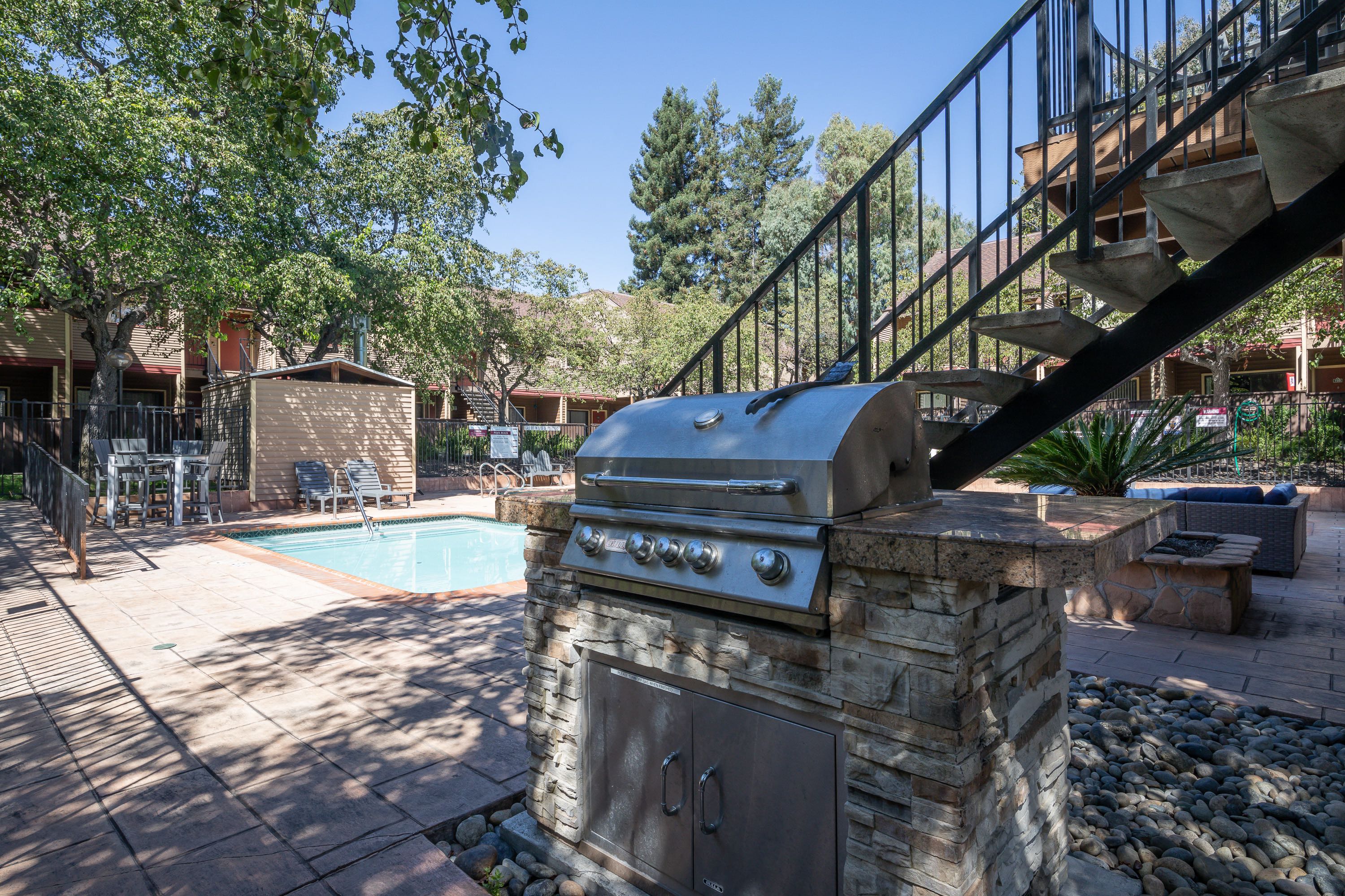 a backyard with a barbecue grill and a swimming pool