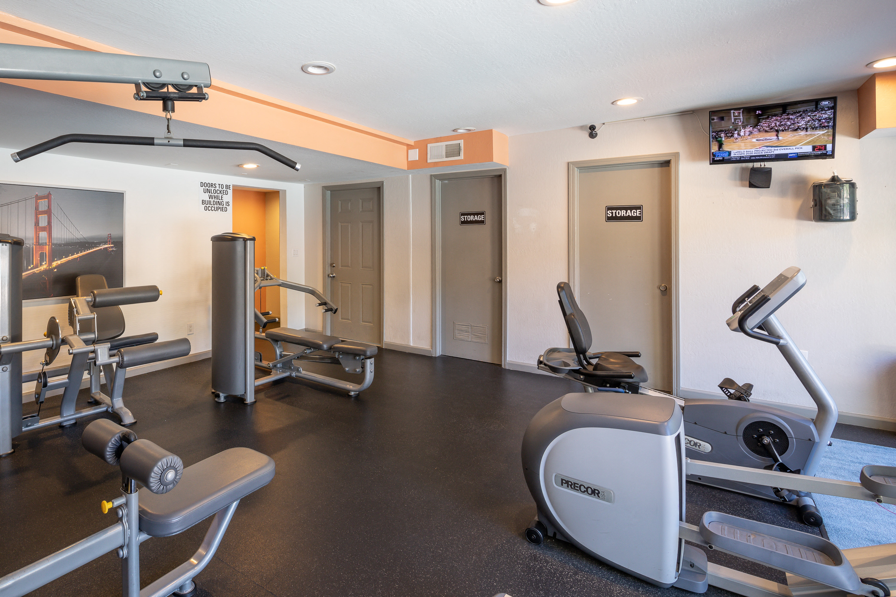 a gym with exercise equipment and a tv