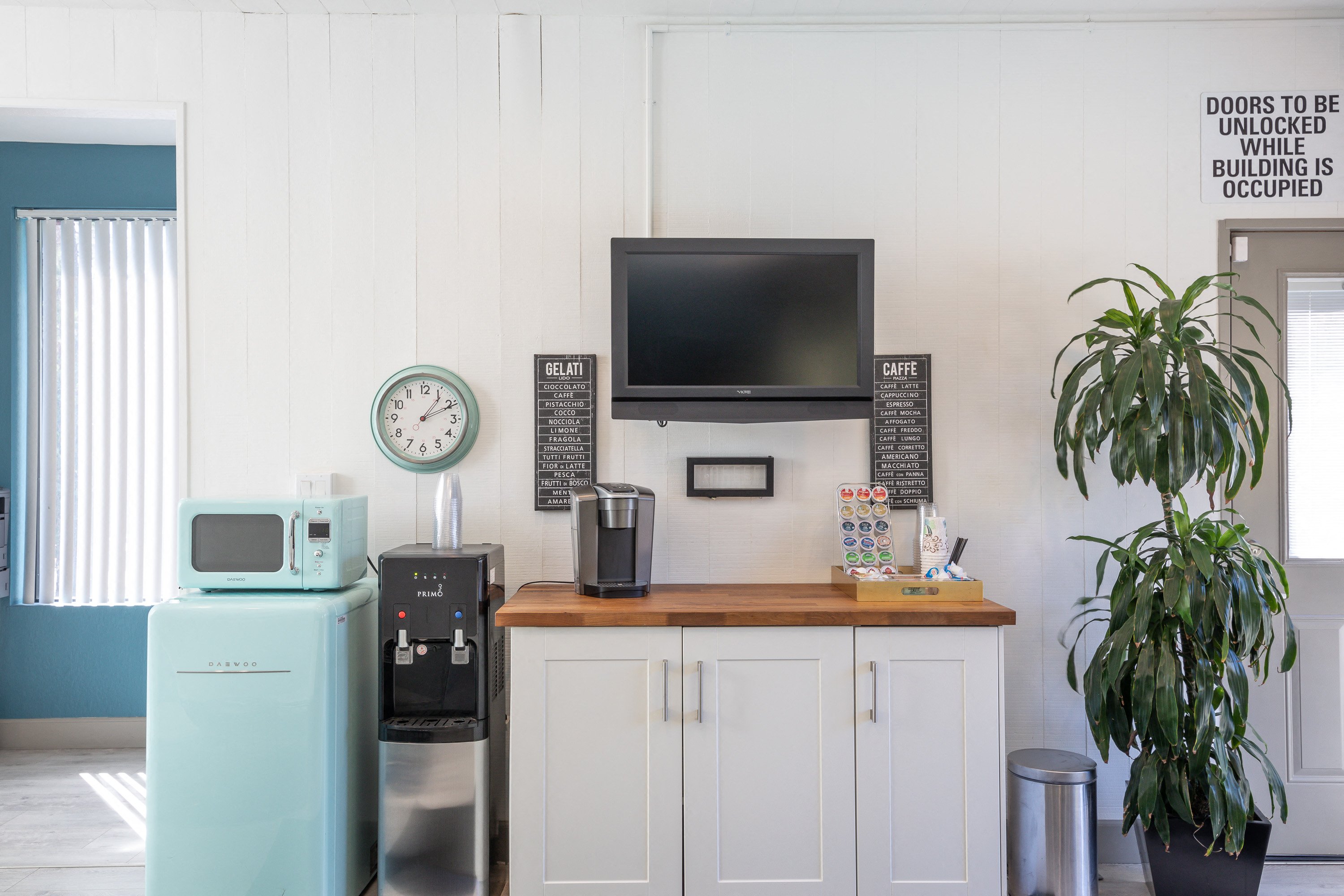 a small kitchen with a microwave and a television
