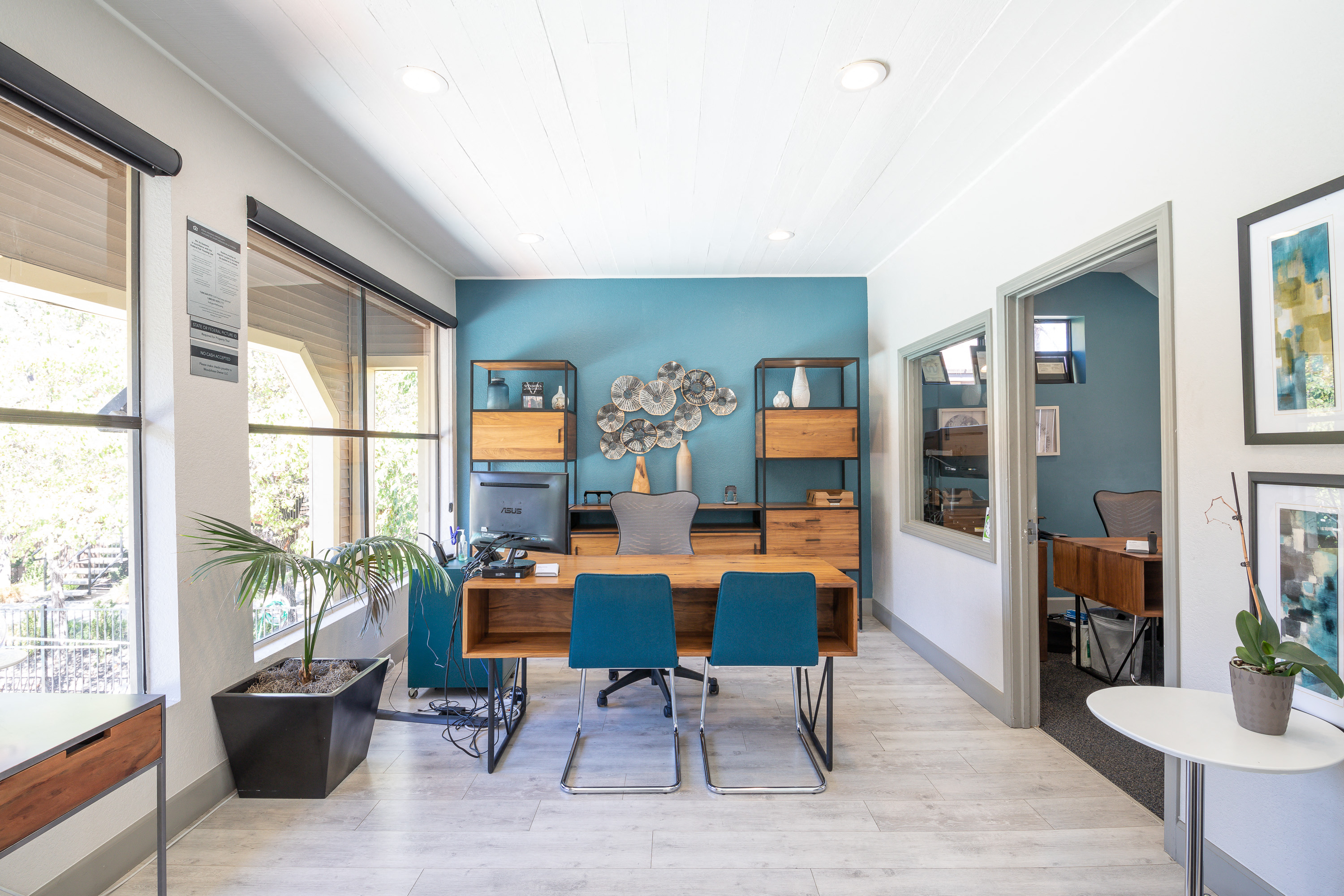 a dining room with blue walls and a wooden table with blue chairs