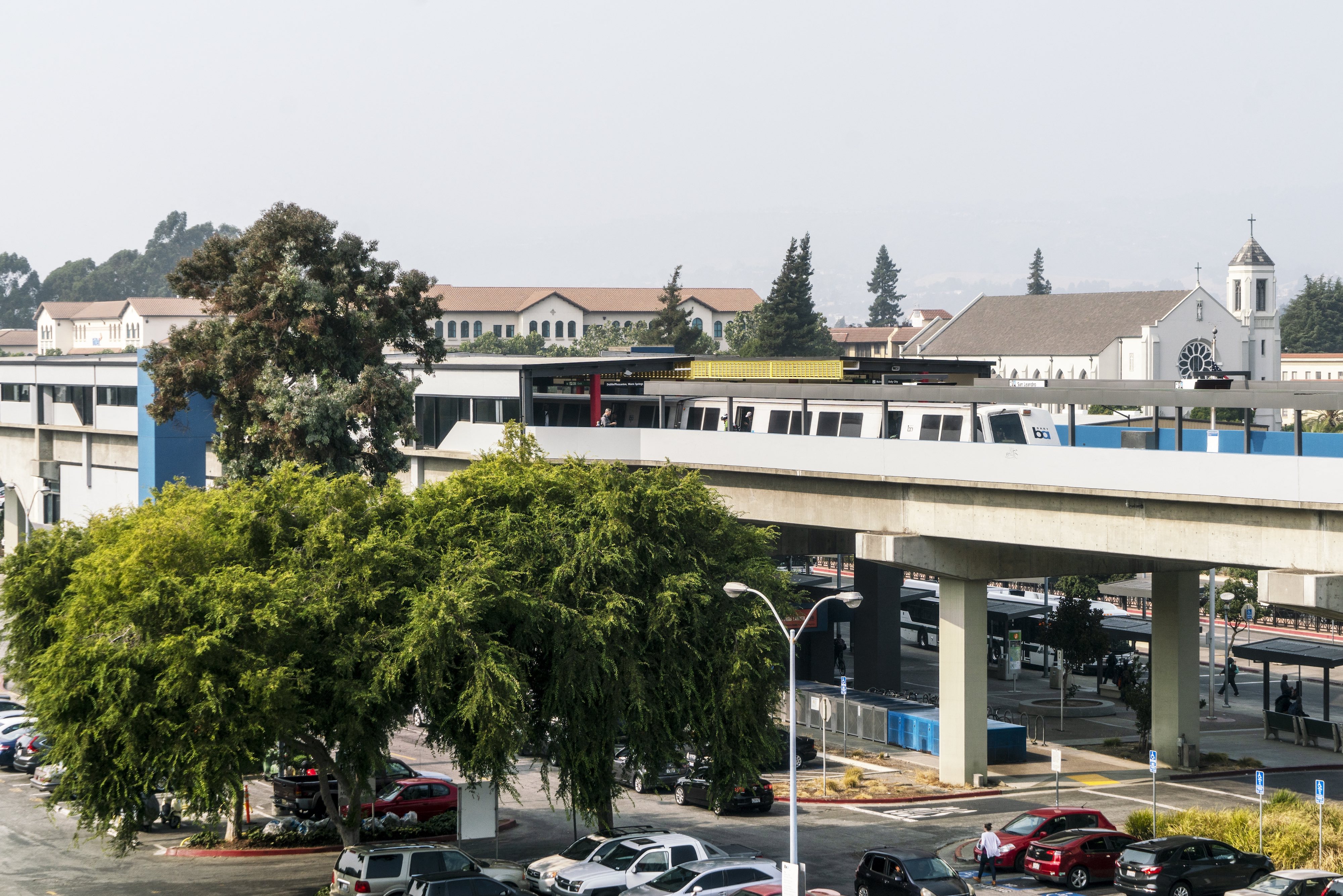 a train on a bridge over a parking lot